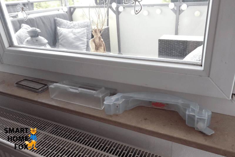 Мобильный резервуар для воды моющего робота-пылесоса сушится на нагревателе.